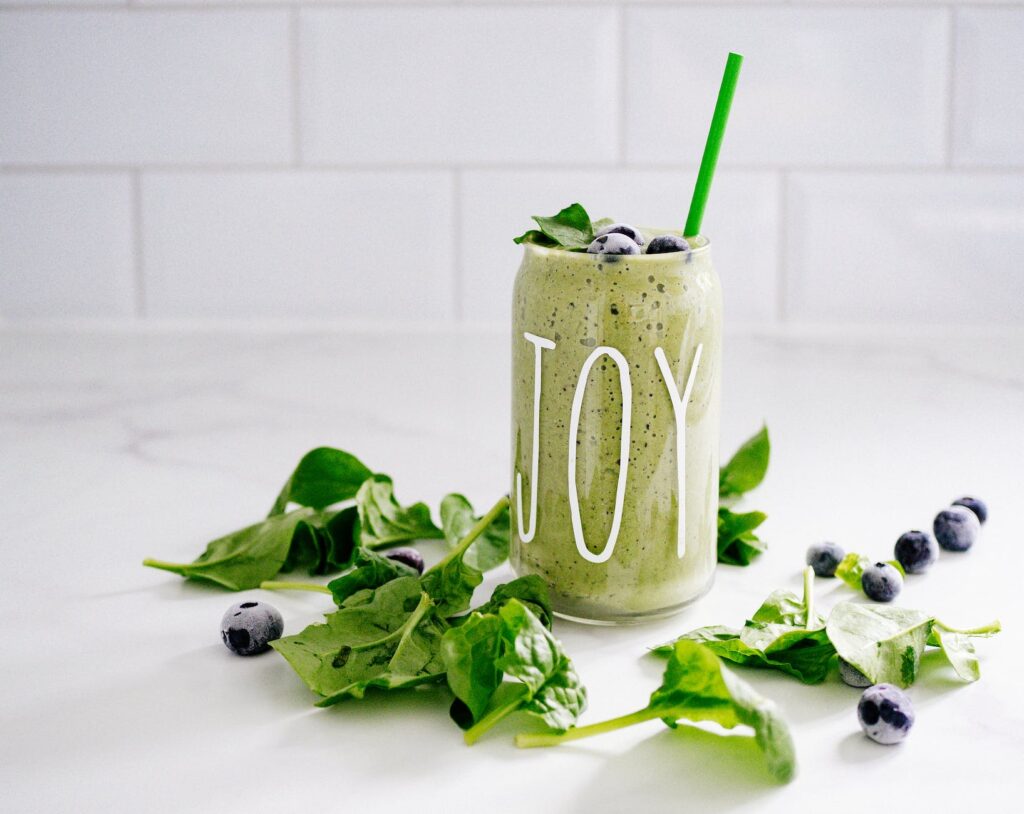 green fruit and veg smoothie served in jar with straw