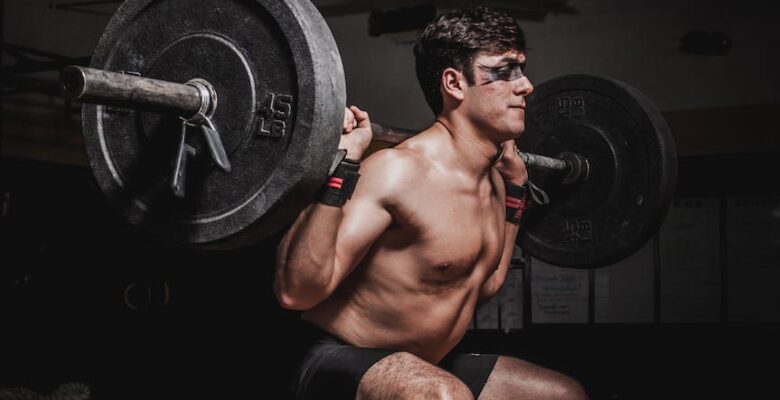 photo of man lifting barbell