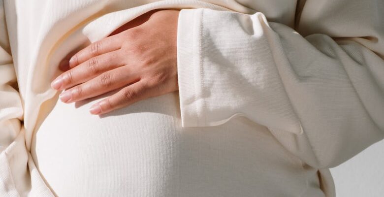 pregnant woman in white long sleeve dress