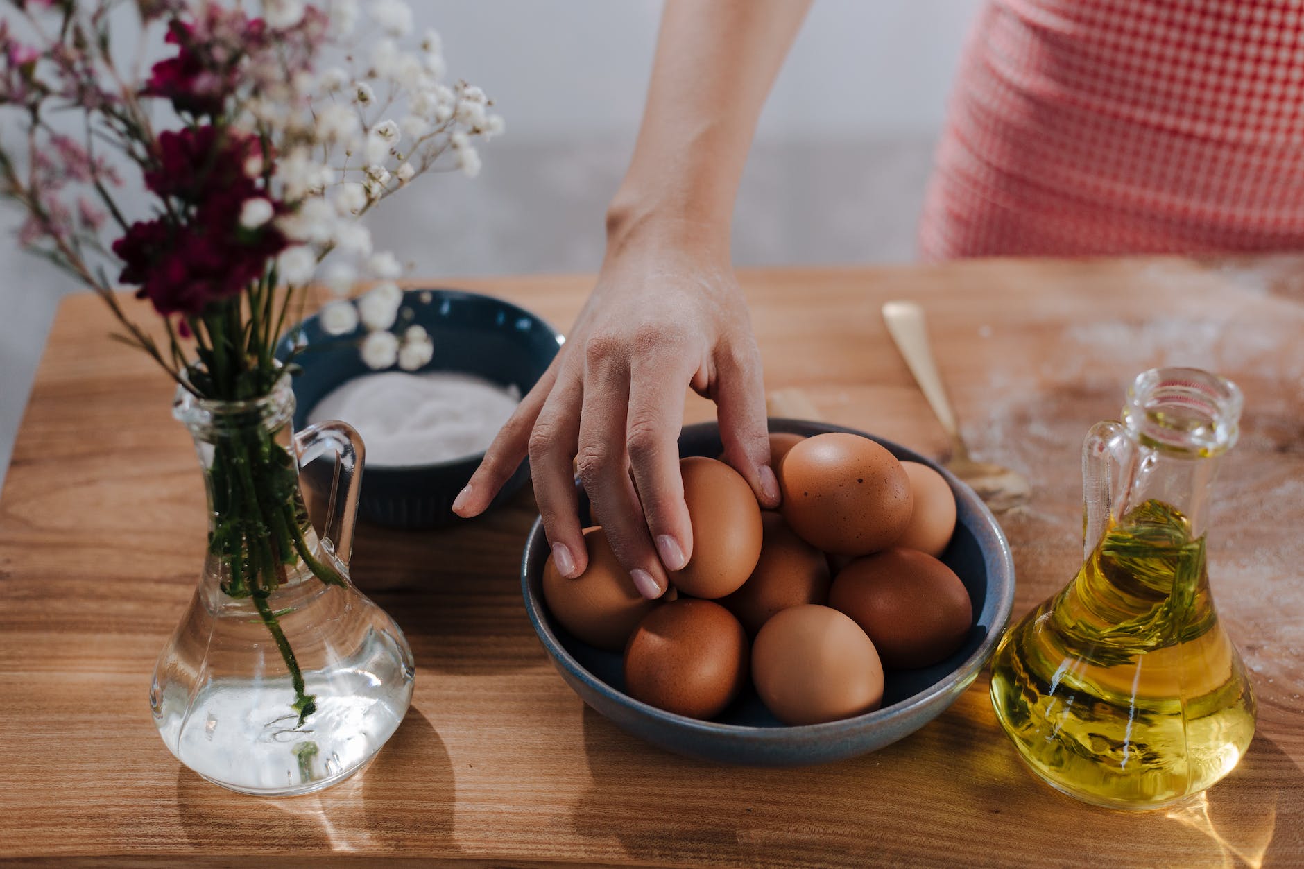 unrecognizable female hand choosing egg from bowl