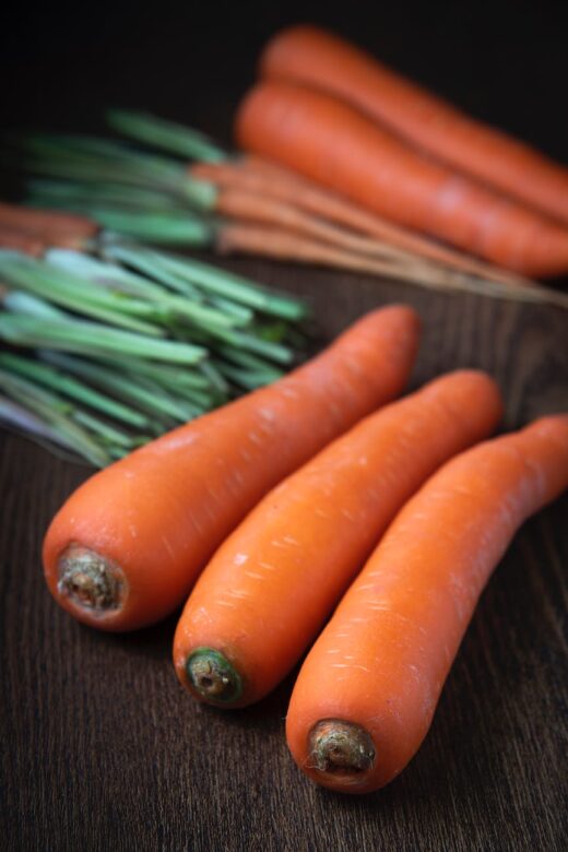 selective focus close up photo of carrots on wooden surface