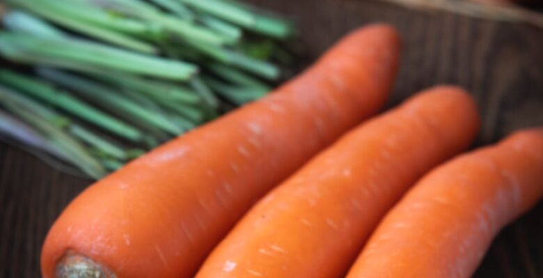 selective focus close up photo of carrots on wooden surface