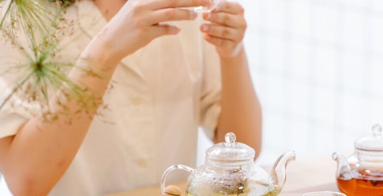 smiling woman brewing tea in glass teapots in the kitchen