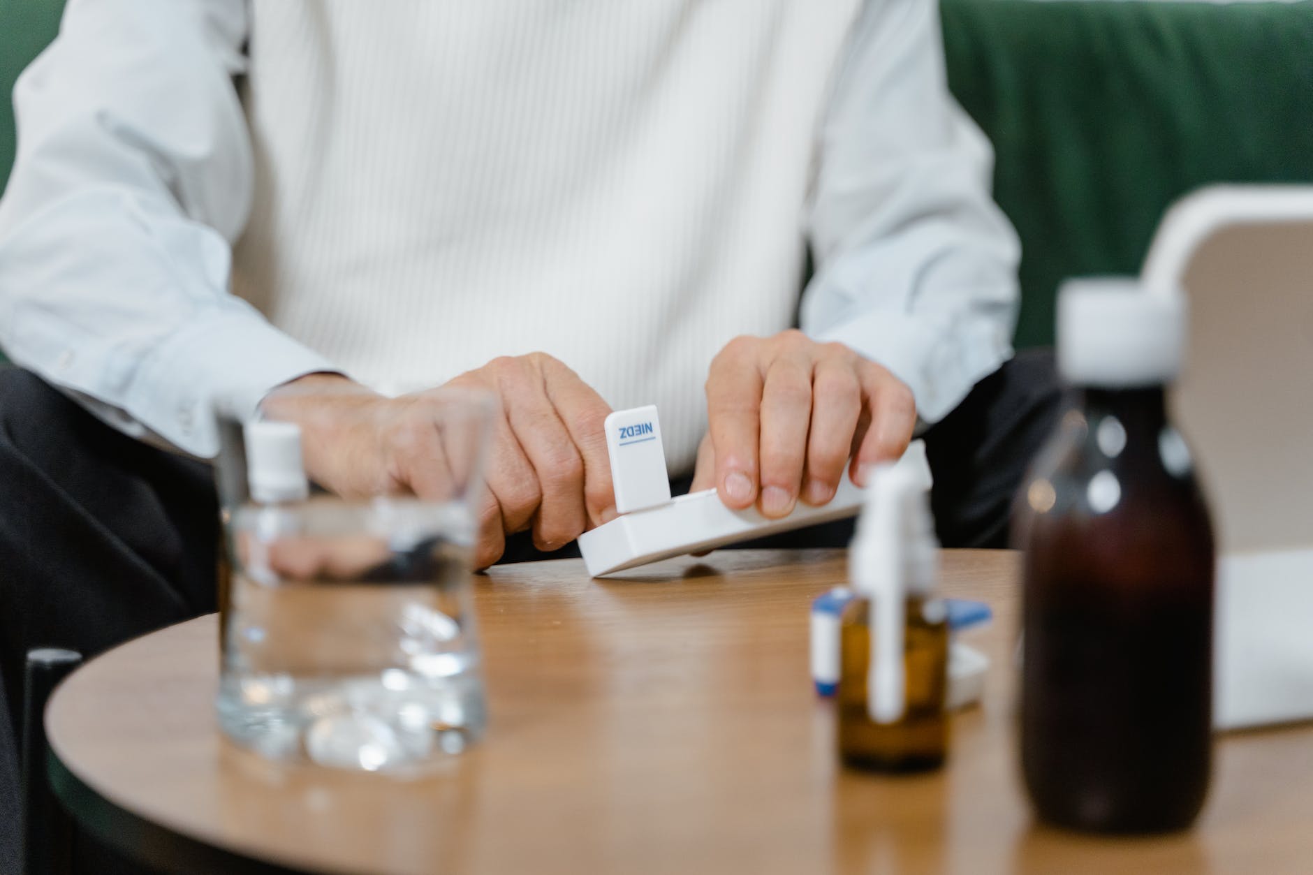 a person using a dosette box for his medicine