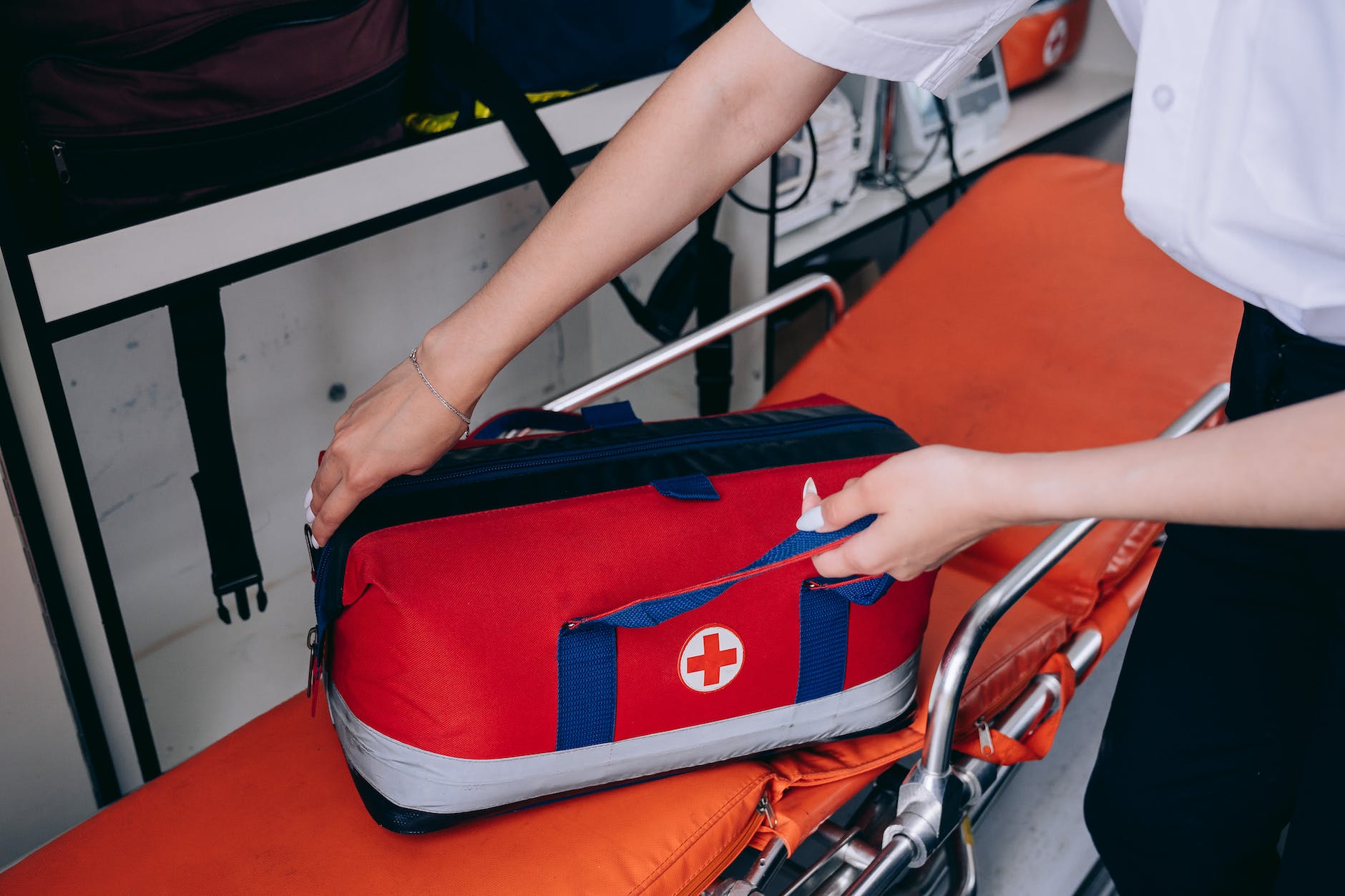 a person holding a first aid kit on a stretcher