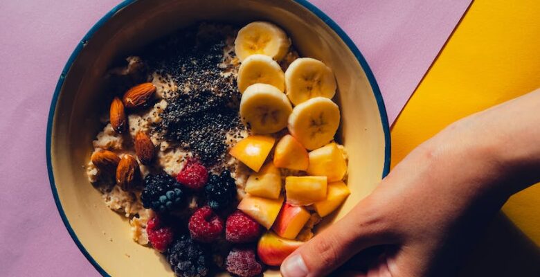 hand holding fruit bowl topped with chia seeds