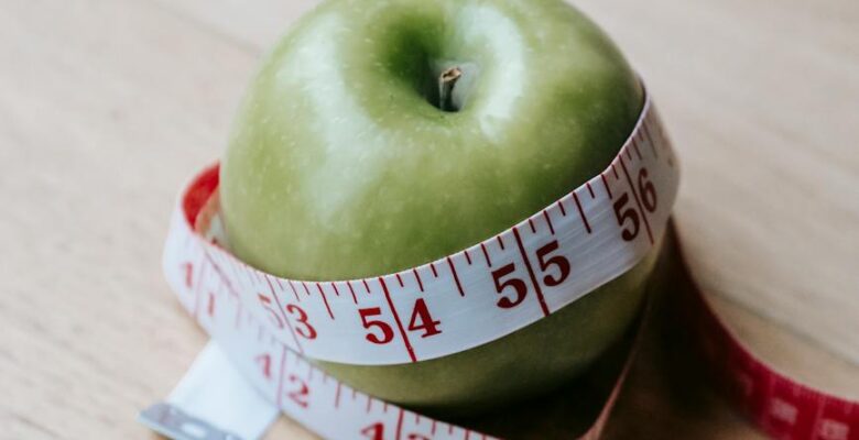 green apple with measuring tape on table in kitchen