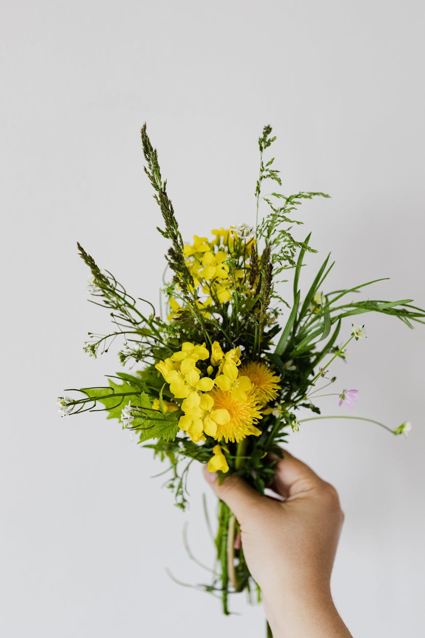 crop person with small bouquet of rural flowers