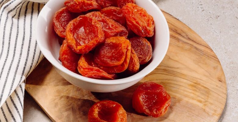 bowl of dried apricots on a cutting board