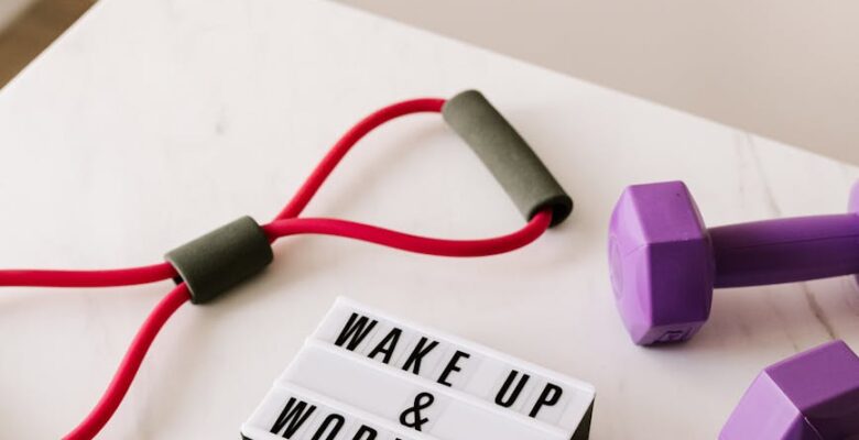 wake up and workout slogan on light box among sports equipment