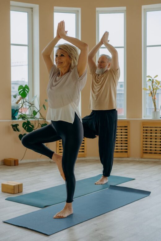 elderly couple standing on yoga mats