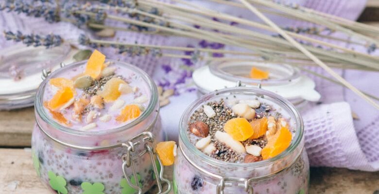 delicious desserts in glass jars beside a pair of spoons and textile