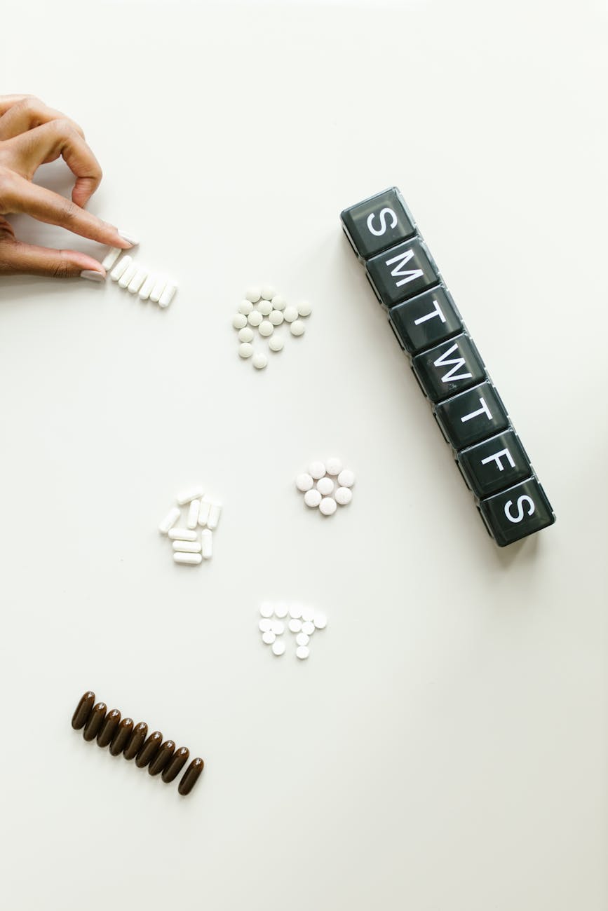 pills and a medicine container on white surface